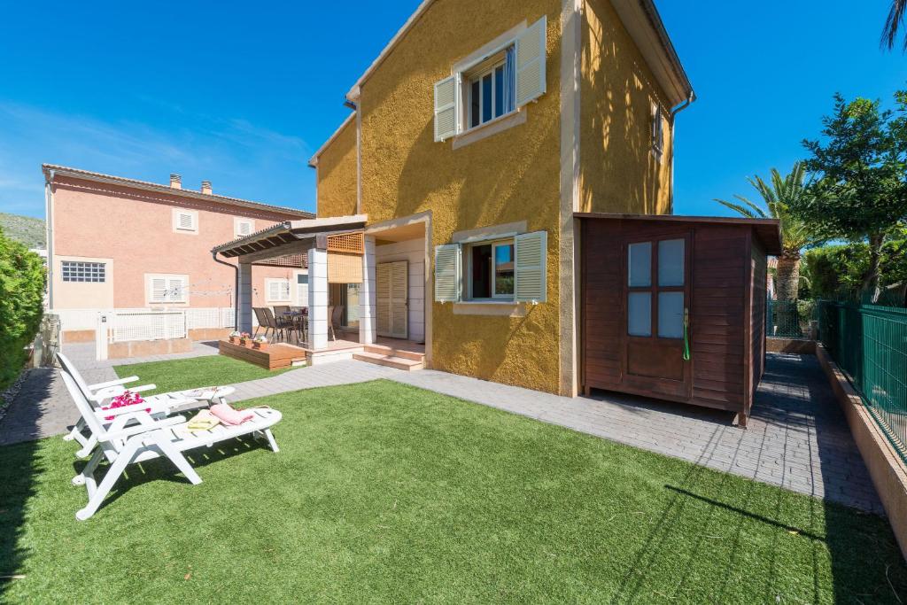 a yard with two chairs and a house at Pereta in Port d'Alcudia