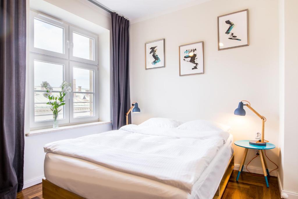 a white bedroom with a bed and a window at NOVUMHOUSE - Tomasza in Krakow