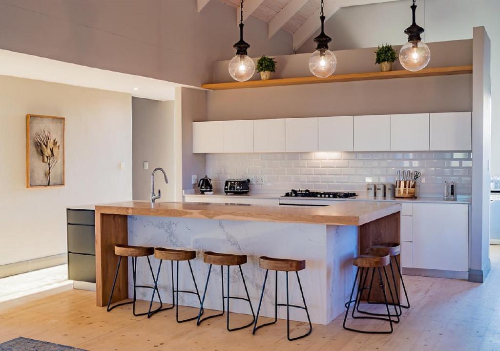 a kitchen with a counter with stools around it at House 222 Gowrie Farm in Nottingham Road