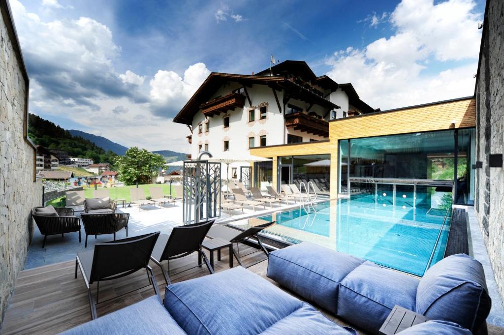 ein Haus mit einem Pool und einer Terrasse in der Unterkunft Hotel Panorama in Ladis