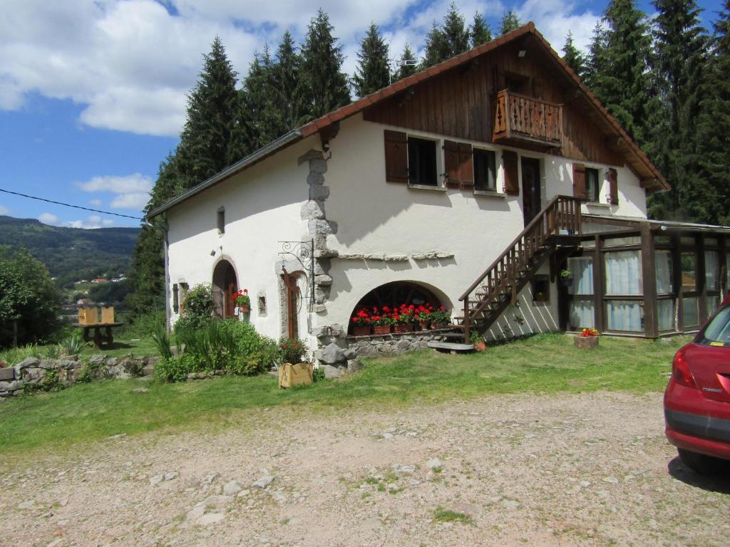 a large white house with a porch and a balcony at La Boissellerie in Saulxures-sur-Moselotte