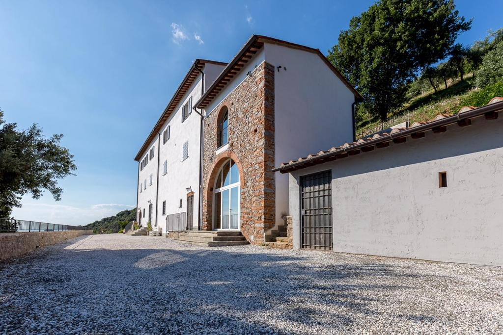 a large white building with a stone driveway at B&B Pietra a Padule in Filettole