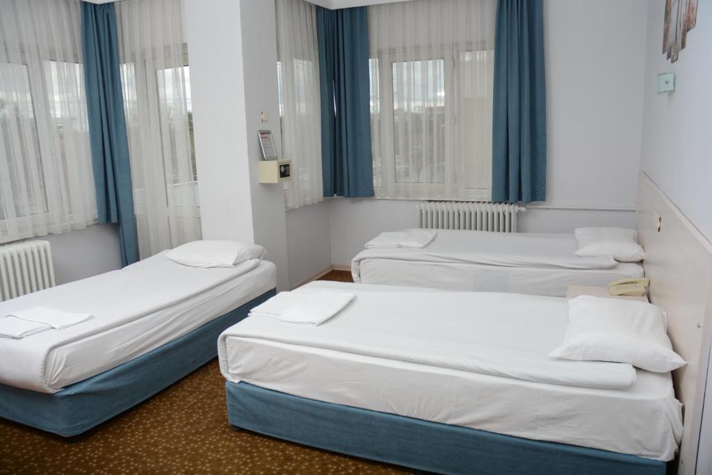 three beds in a small room with windows at Oreko Express in Afyon