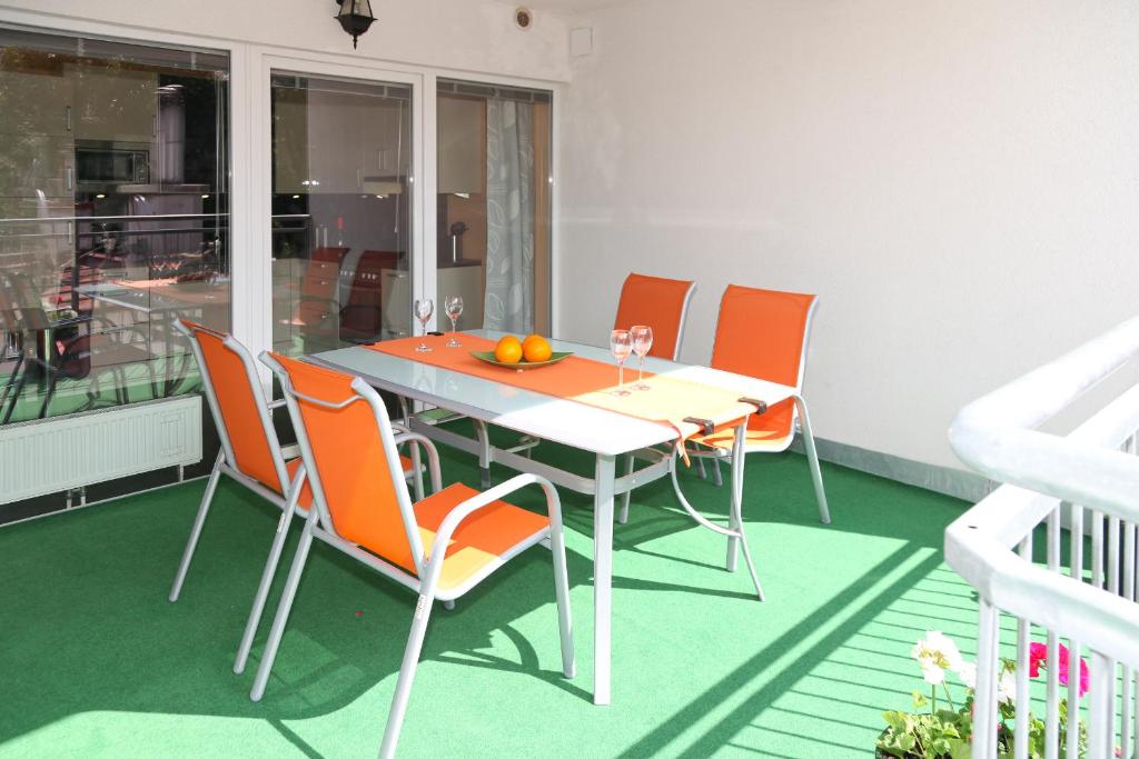 a dining table with orange chairs on a balcony at 3 rooms Sunny Apartments-Schoenbrunn, 100m2 with balcony in Vienna