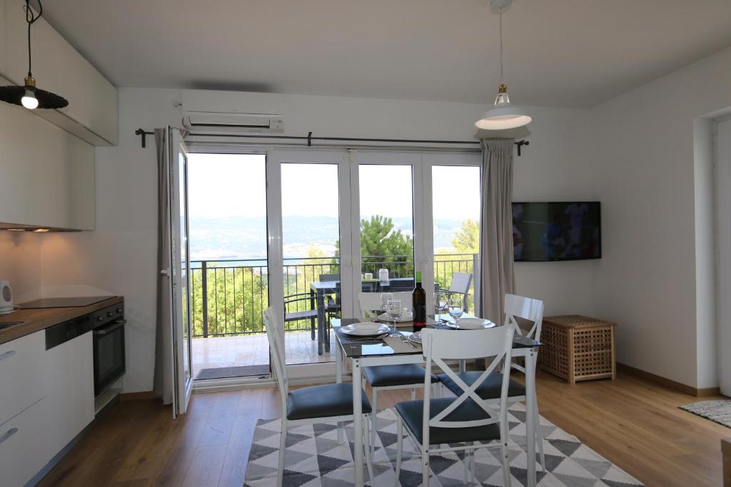 Una cocina y un comedor con mesa y sillas. en Apartments Baresic, en Šilo