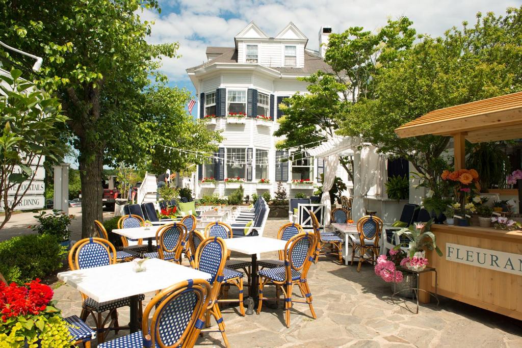 um pátio com mesas e cadeiras em frente a um edifício em Kennebunkport Inn em Kennebunkport