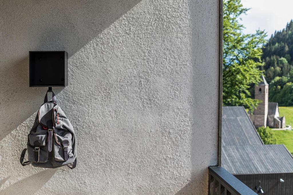 a backpack hanging on the side of a wall at Miramonti Boutique Hotel in Avelengo