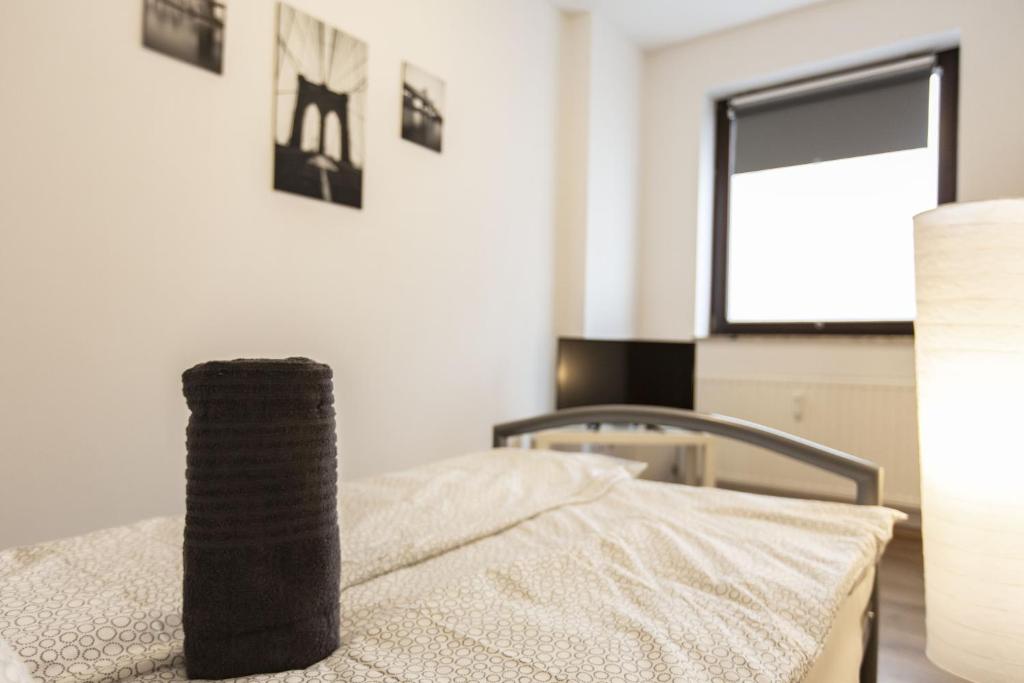 a bedroom with a bed with a window and a table at AVR Apartment HOF 1 in Bremerhaven