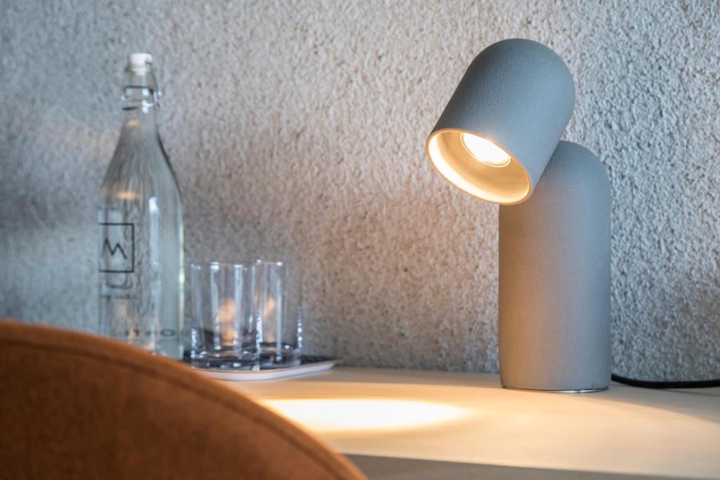a light on a table with glasses and a bottle at Miramonti Boutique Hotel in Avelengo