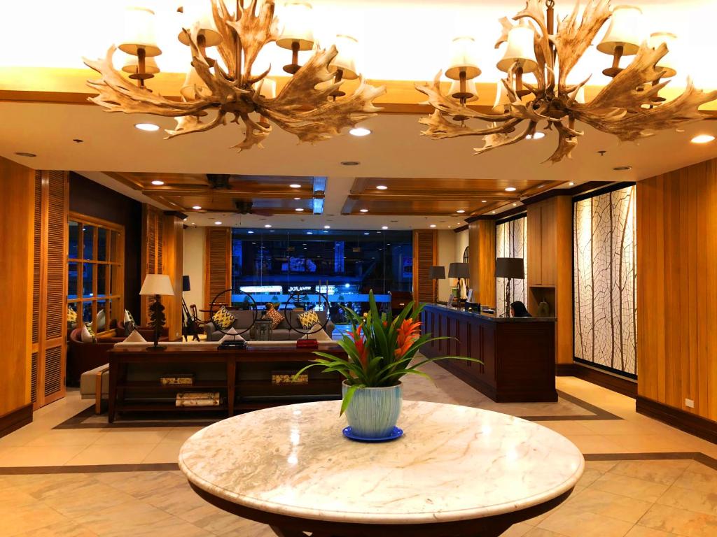 een lobby met een tafel met een vaas met bloemen erop bij Cedar Peak Condominium by Tripsters Hub in Baguio