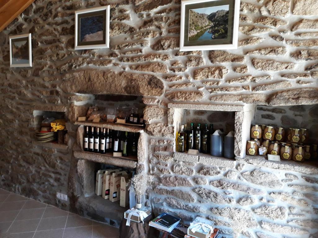 uma parede de pedra com garrafas de vinho em Cidadelhe Rupestre Turismo Rural em Cidadelhe