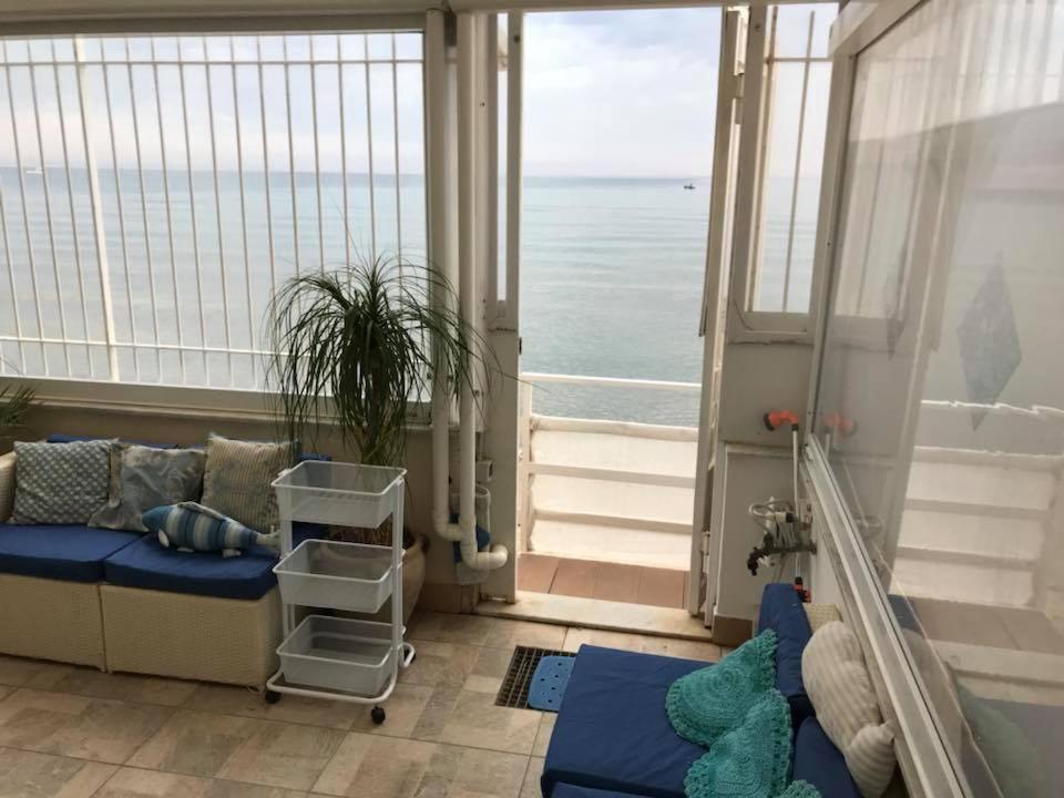 uma sala de estar com um sofá e vista para o oceano em La Battigia B&B em Trabia