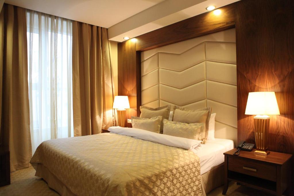 - une chambre avec un lit, deux lampes et une fenêtre dans l'établissement Volga Premium Hotel, à Tcheboksary