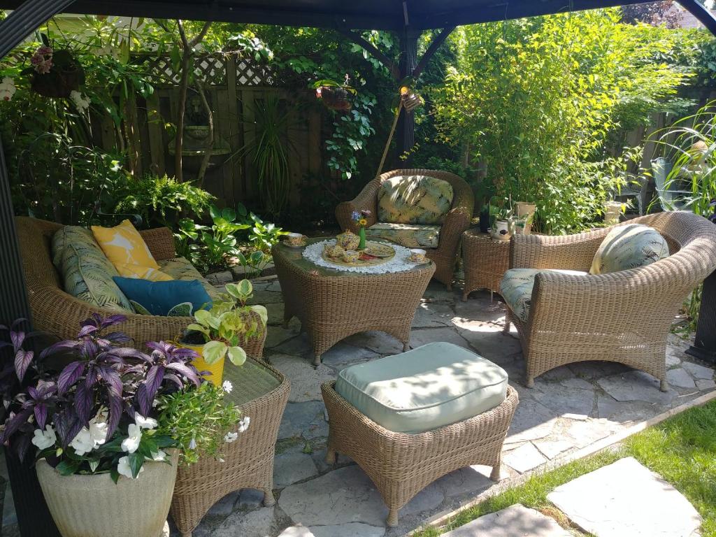 a patio with wicker chairs and tables and an umbrella at TwiningRetreat in Niagara on the Lake