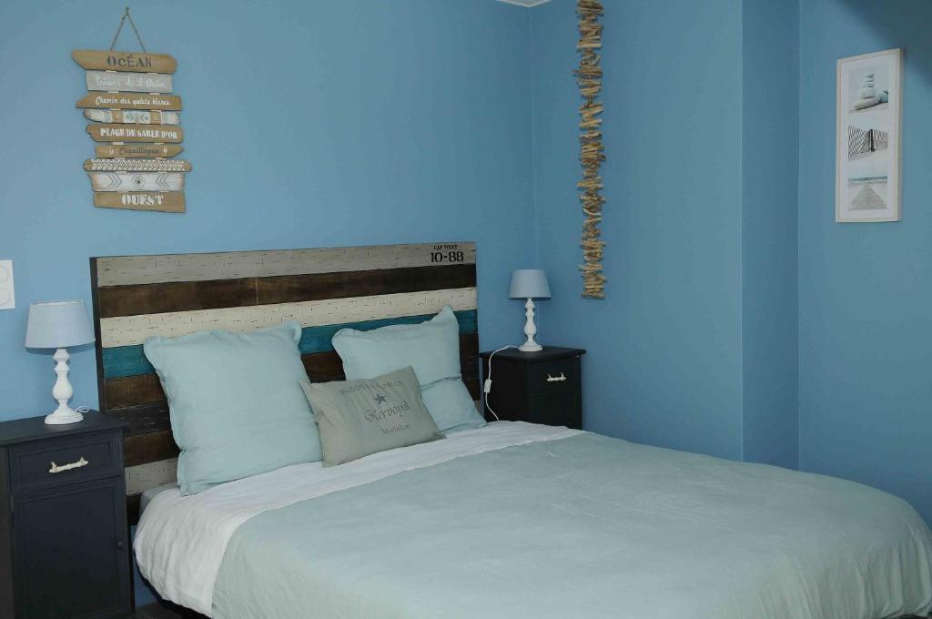 una camera blu con un grande letto con pareti blu di Les loges de l'ecurie a Damgan