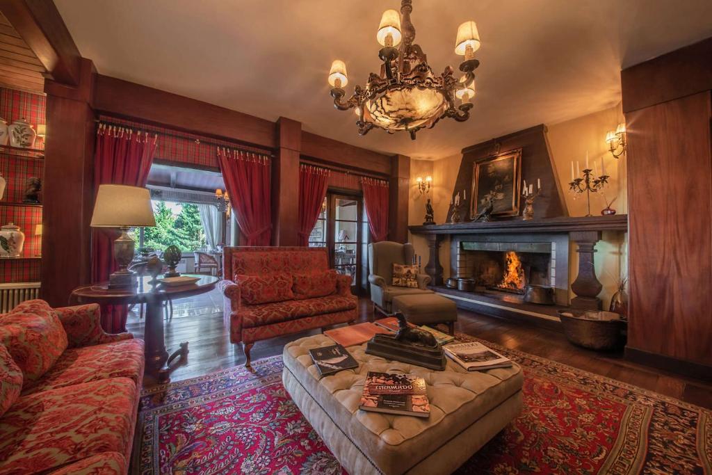 uma sala de estar com um sofá e uma lareira em Hotel Casa da Montanha em Gramado