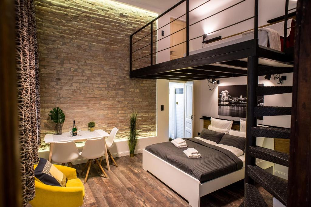 1 dormitorio con cama elevada y comedor en Very stylish and fresh studio home in the center, en Budapest