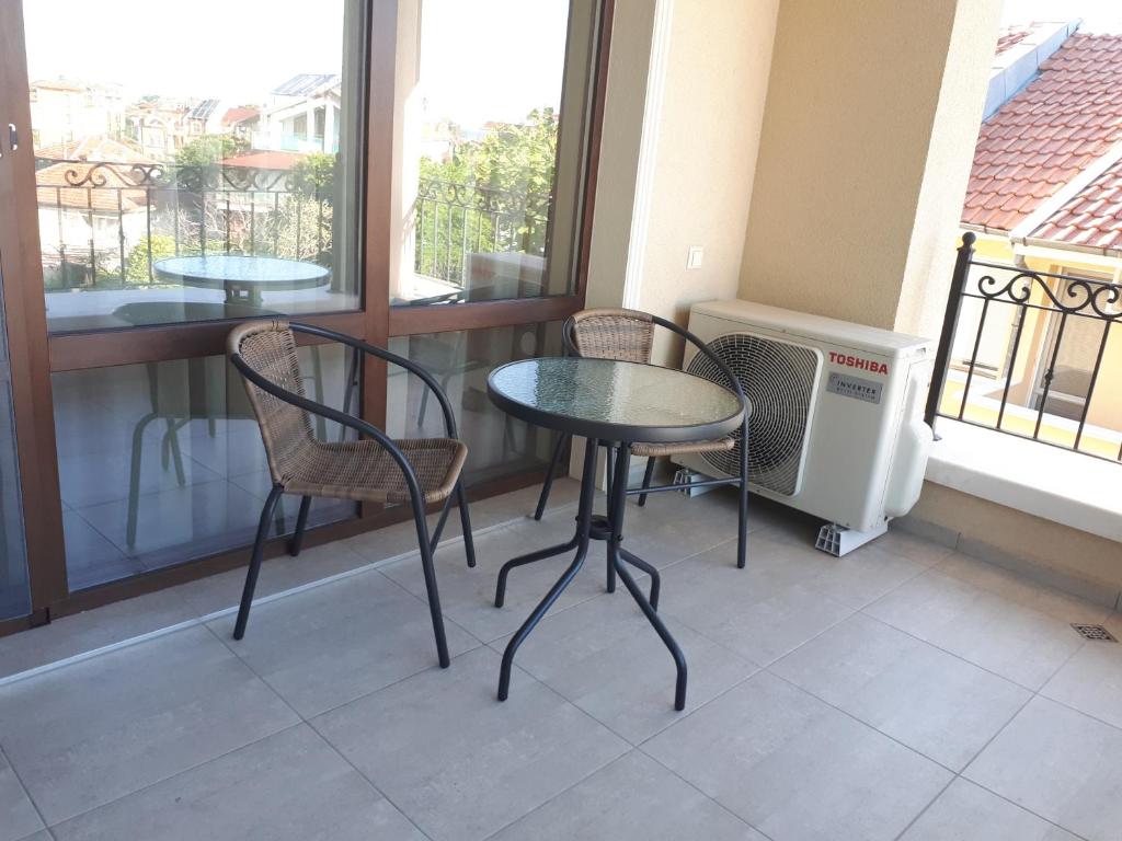 a table and two chairs on a balcony with a window at Gradina in Chernomorets