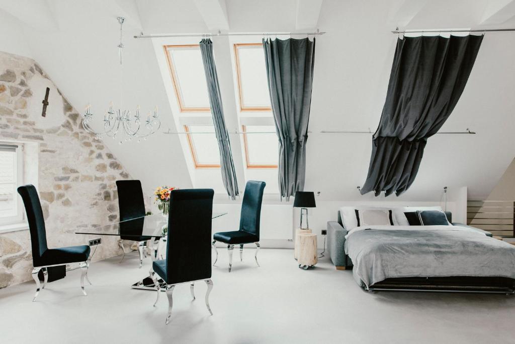 sypialnia z łóżkiem, stołem i krzesłami w obiekcie Coco Chanel Boutique Apartment by Goodnite cz w mieście Brno