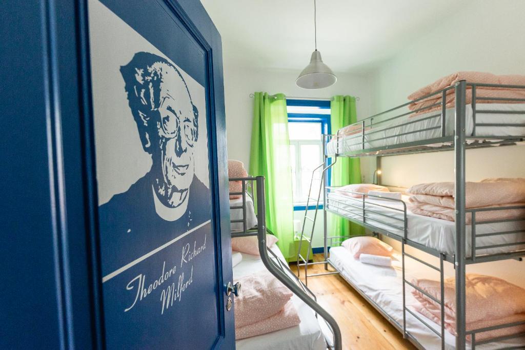 パレーデにあるHelp Yourself Hostels - Paredeの二段ベッドと男性のポスターが備わる部屋