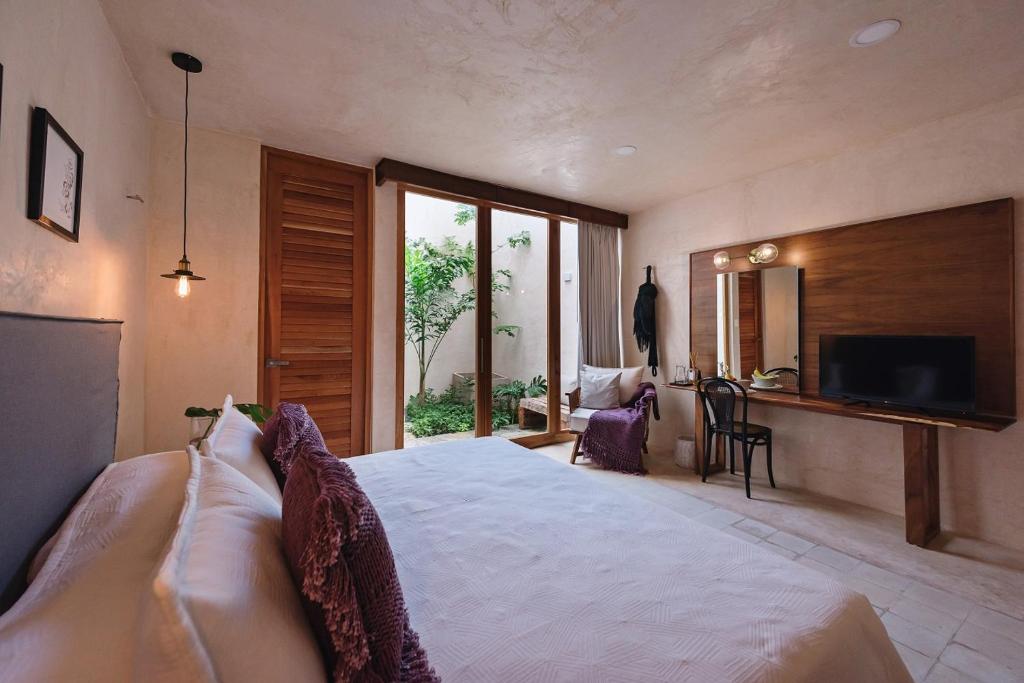 um quarto com uma cama grande e uma televisão em Colonte Hotel Origen em Valladolid
