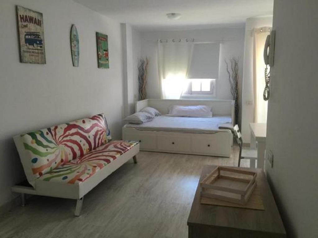 a living room with a bed and a couch at Apartamento Casita Blanca in Corralejo