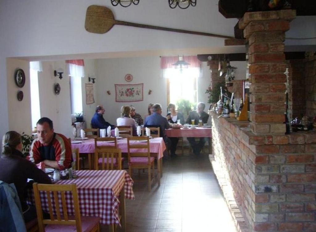 grupa ludzi siedzących przy stolikach w restauracji w obiekcie Bényei Fogadó Panzió és Étterem w mieście Erdőbénye