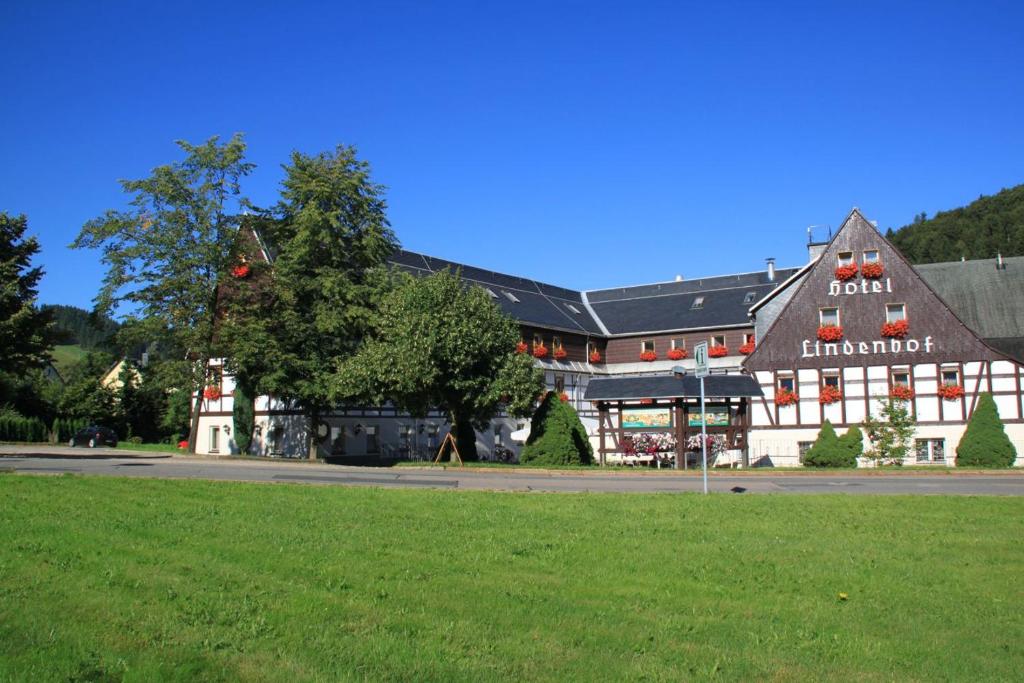 ein großes Gebäude mit einem grünen Feld davor in der Unterkunft Naturhotel Lindenhof in Rechenberg-Bienenmühle