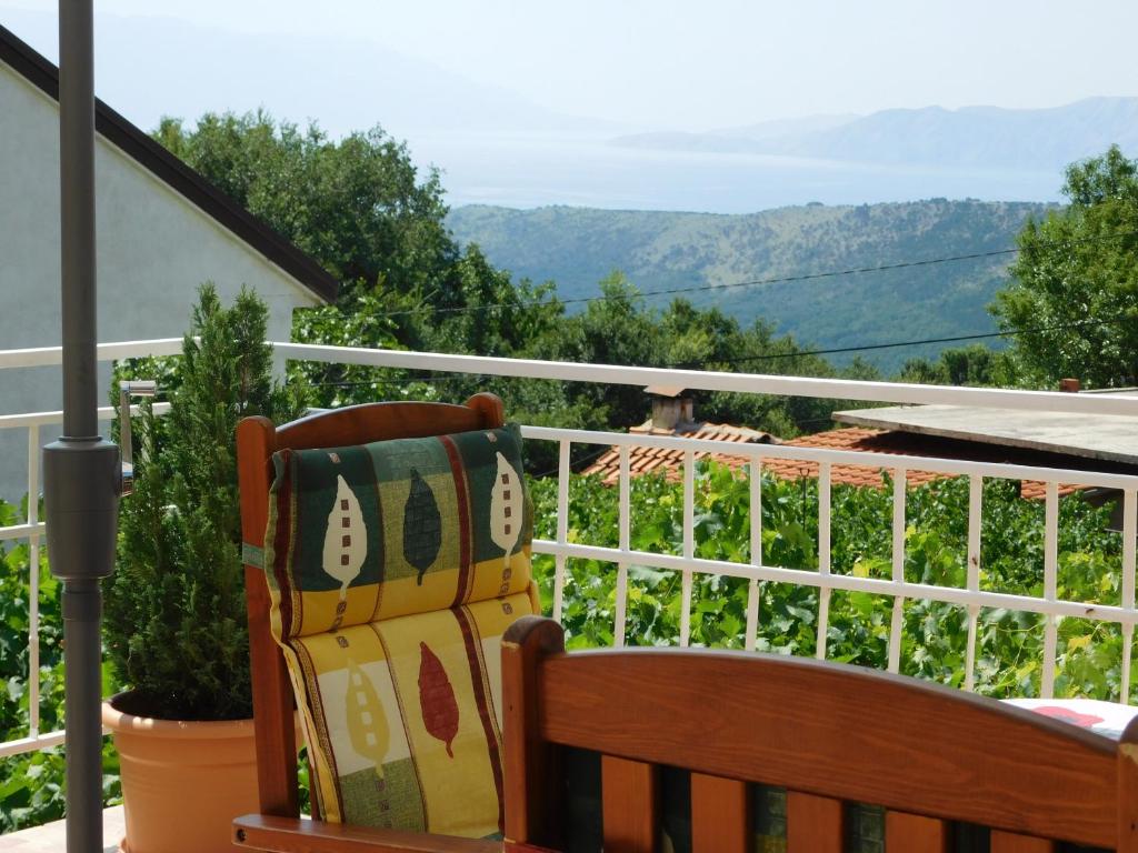 a wooden chair sitting on a balcony with a view at Apartment Varelija in Bribir