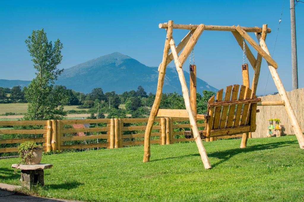 un columpio en la hierba con una montaña en el fondo en Rtanjski konak, en Boljevac
