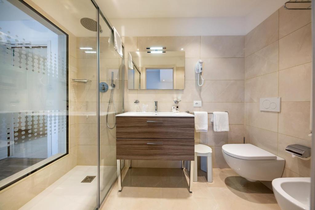 a bathroom with a sink and a toilet and a shower at International Beach Hotel in Caorle