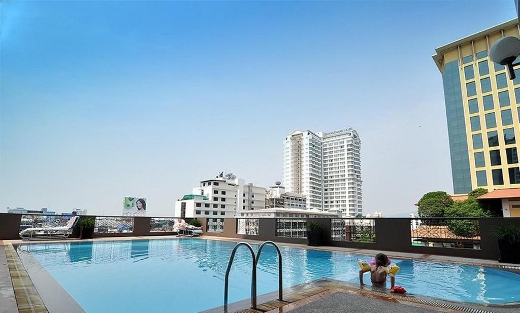 a child playing in a swimming pool on top of a building at Royal Lanna Hotel in Chiang Mai