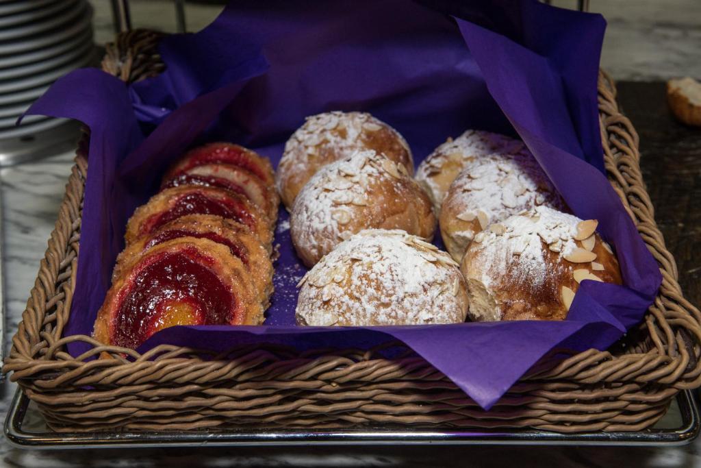 A close-up basket of assorted sweet pastries on purple paper.