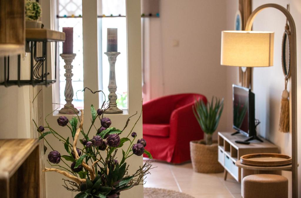 un soggiorno con sedia rossa e TV di Petite Fleur a Preveza