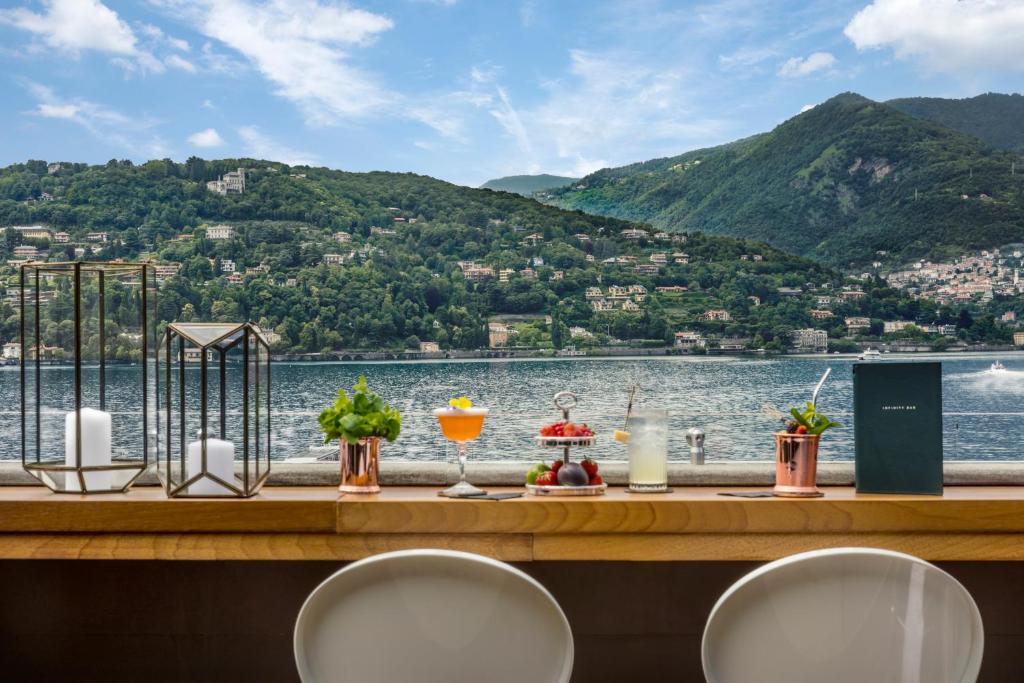 una mesa con vistas al agua y a las montañas en Vista Palazzo - Small Luxury Hotels of the World en Como