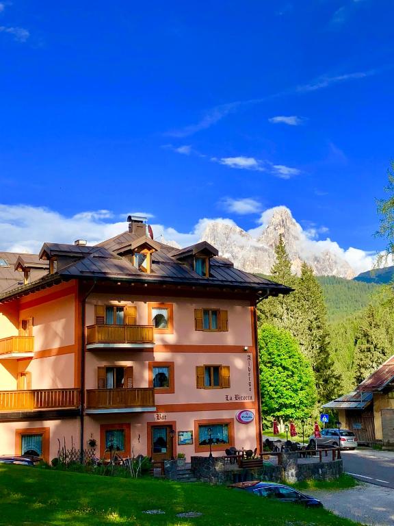 a building with a mountain in the background at Albergo La Bicocca in Paneveggio