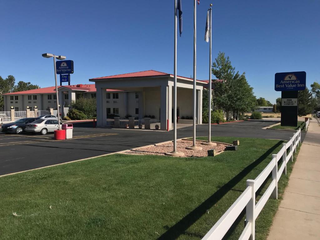 a building with a fence in front of a parking lot at Americas Best Value Inn Cedar City in Cedar City