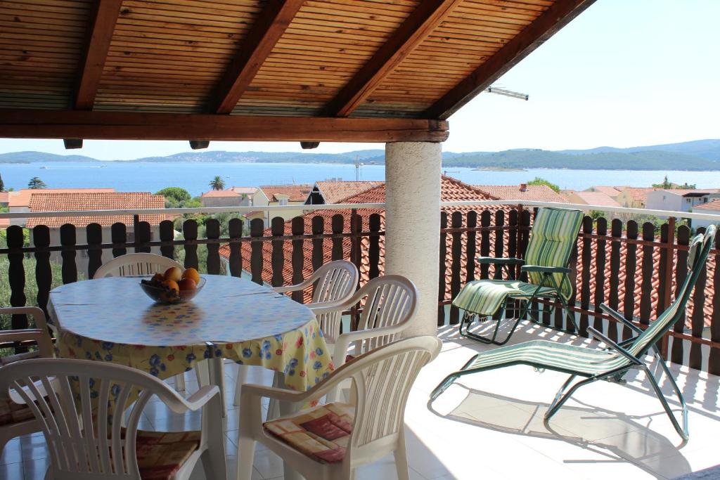 a table and chairs on a patio with a view of the ocean at Apartments Vidic in Orebić