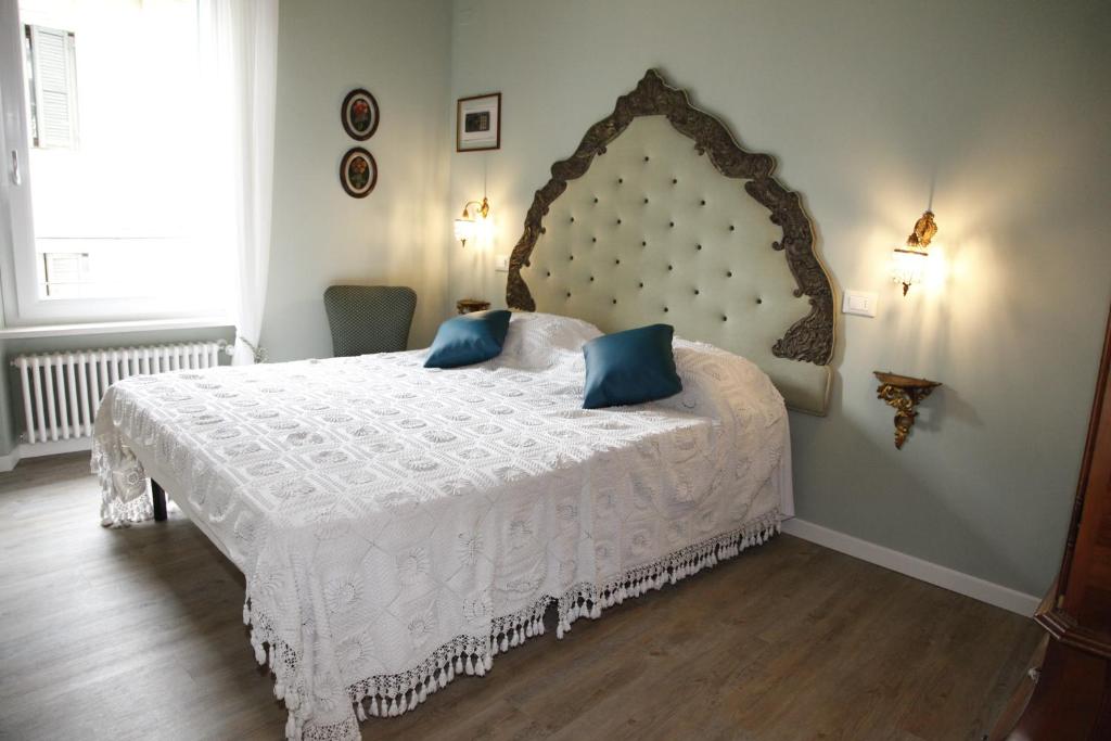 una camera da letto con un grande letto bianco con cuscini blu di Juliet's nest in Verona a Verona
