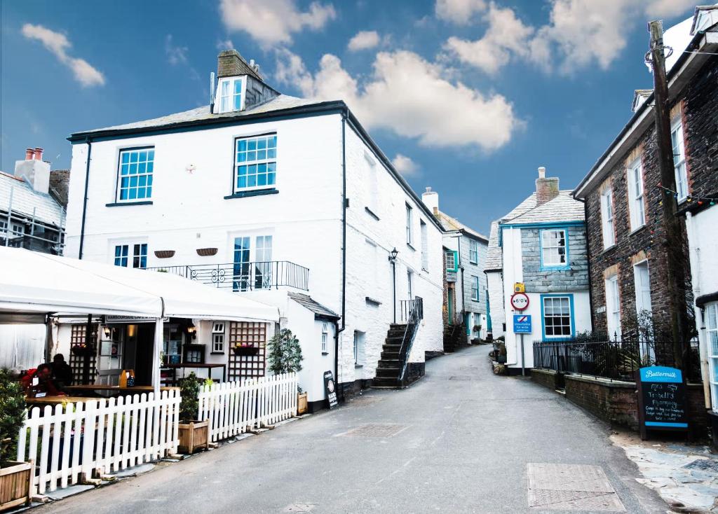 eine Straße mit weißen Gebäuden und einem weißen Zaun in der Unterkunft The Slipway in Port Isaac