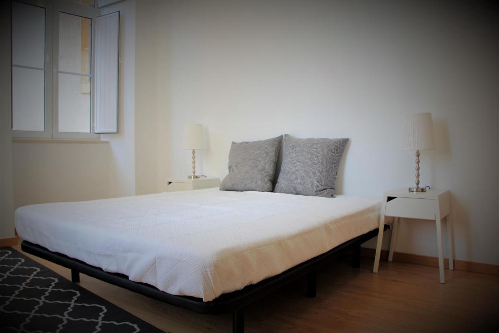 コインブラにあるOrpheus - Portagem - UNESCO Heritageのベッドルーム(白い大型ベッド、ランプ2つ付)