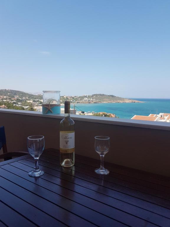 a bottle of wine sitting on a table with two glasses at Evangelia in Karfas