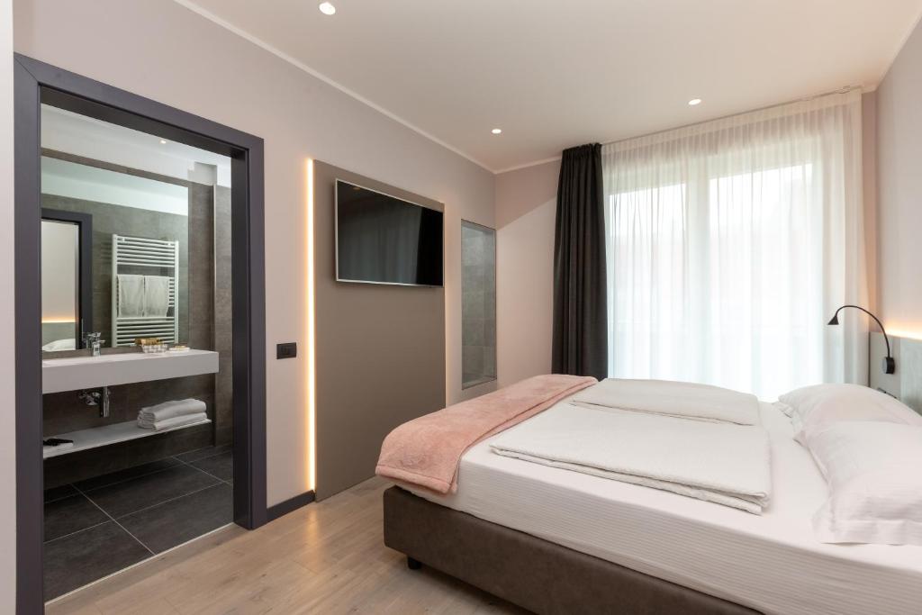 a bedroom with a bed and a sink and a mirror at Garda Life in Riva del Garda