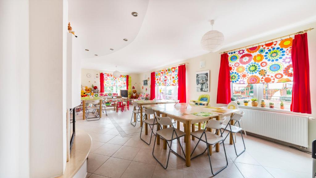 a dining room with red curtains and a table and chairs at Villa Malva in Karwia