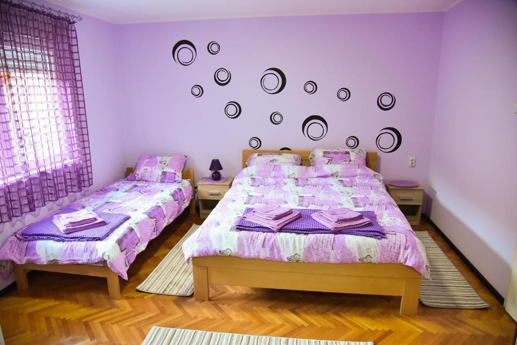 een slaapkamer met 2 bedden en een muur met spiegels bij PRENOĆIŠTE PILOT in Niš