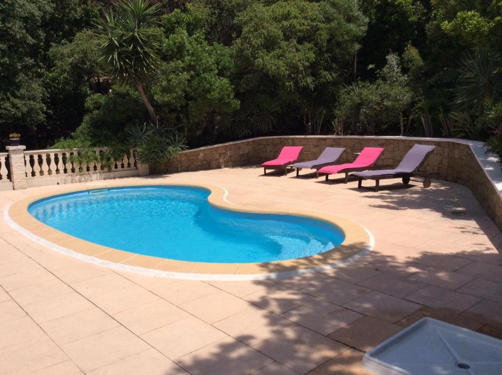 uma piscina com duas cadeiras e uma piscina em Gites Ugliastru PORTICCIO em Eccica-Suarella