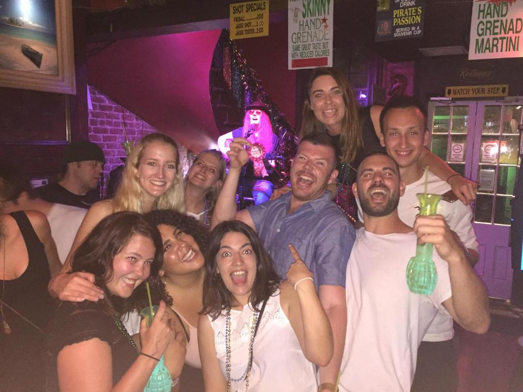 a group of people posing for a picture in a club at HOSTEL Auberge NOLA in New Orleans