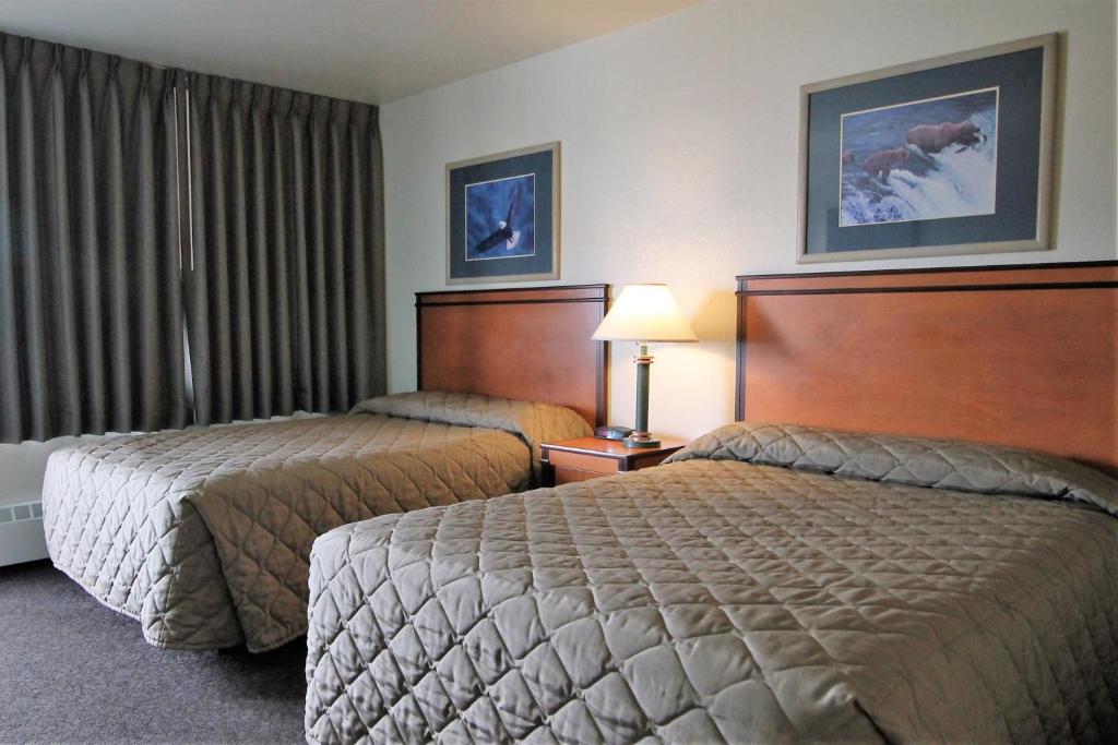 ein Hotelzimmer mit 2 Betten und einem Fenster in der Unterkunft Breeze Inn Motel in Seward