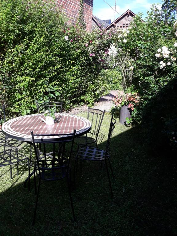 einen Tisch und Stühle in einem Garten mit Blumen in der Unterkunft Gite au bord du Lac in Montville
