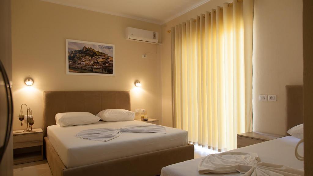 a hotel room with two beds and a window at Villa Balani in Durrës